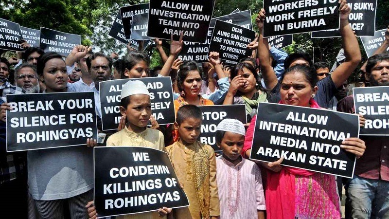 Refugiados musulmanes Rohingyas junto con partidarios de la India sostienen pancartas contra las violaciones de los derechos humanos en Myanmar